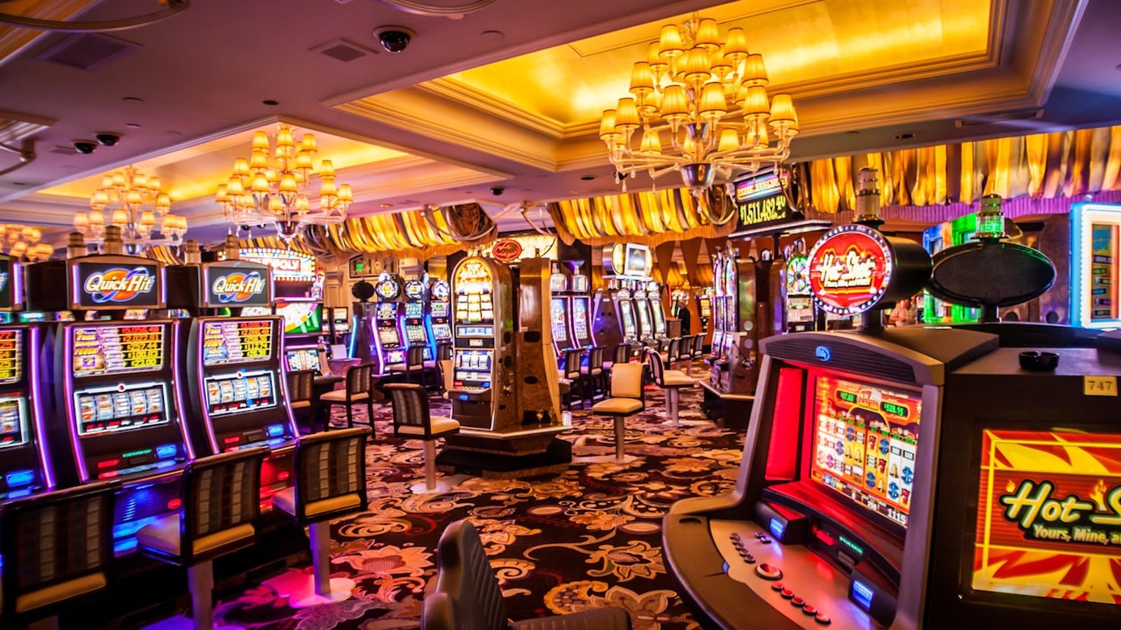 Suasana lantai kasino modern dengan deretan mesin slot